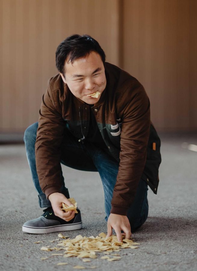 Senior Kevin Kim eats tortilla chips that briefly fell on a sidewalk on Palo Alto High School campus. Since concrete is a relatively smooth surface, bacterial transfer was likely minimal and harmless. 