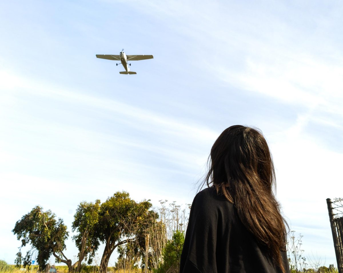 An onlooker watches as a Cessna 172s approaches the Palo Alto Airport